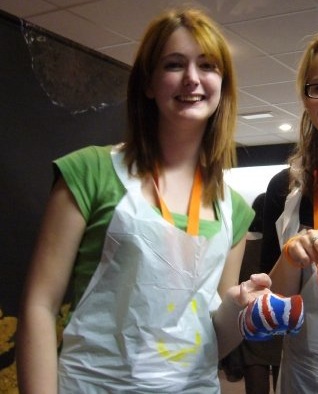 two women in aprons holding up a carrot