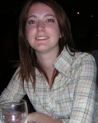 a woman sitting at a table with a wine glass