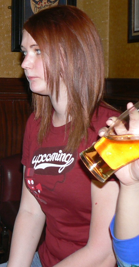 a woman sitting on a couch holding a beer