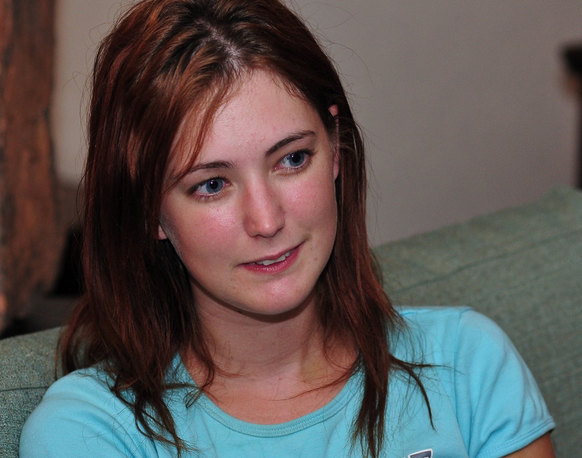 a woman sitting on a couch holding a cellphone