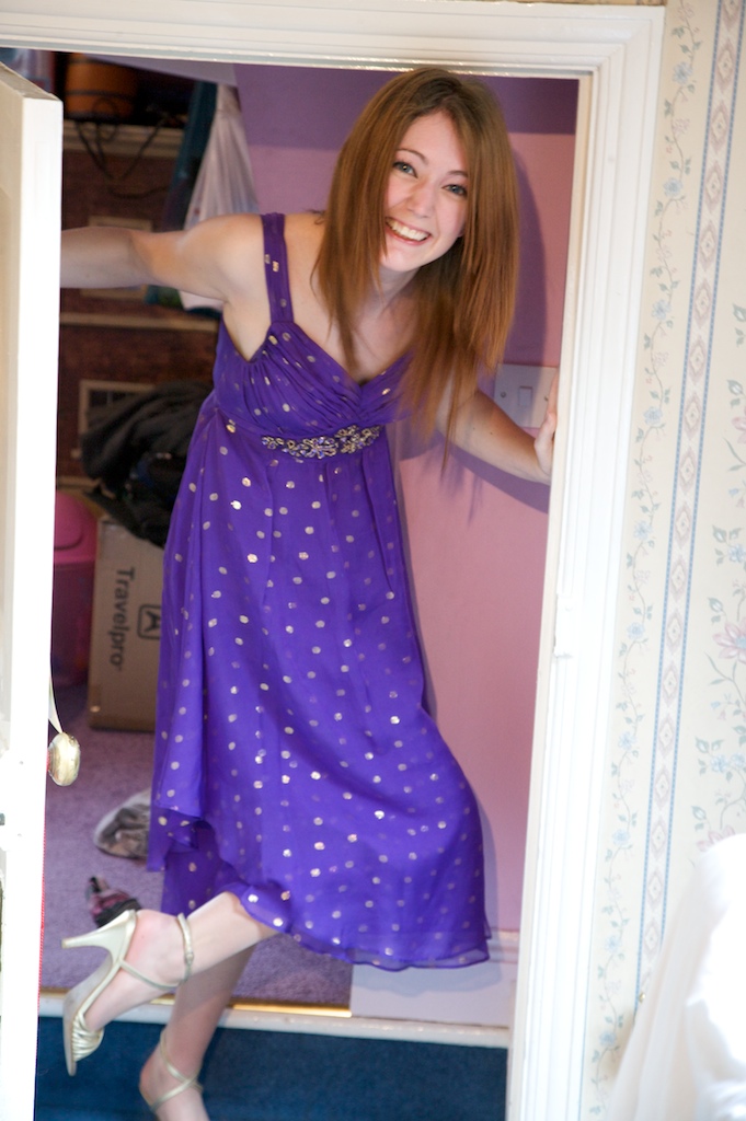 a woman in a purple dress is standing in a doorway