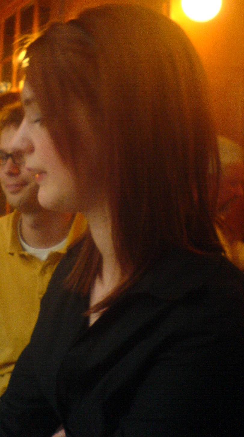 a woman sitting at a table with a cellphone