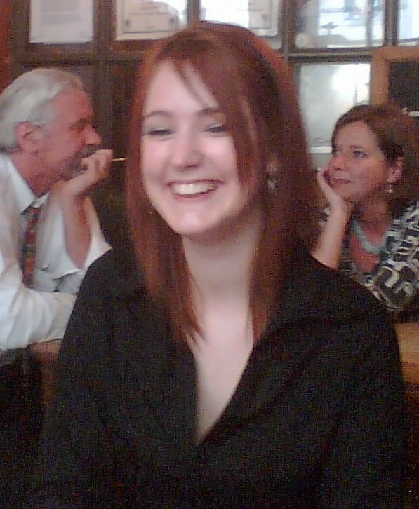 a woman sitting at a table with a cellphone