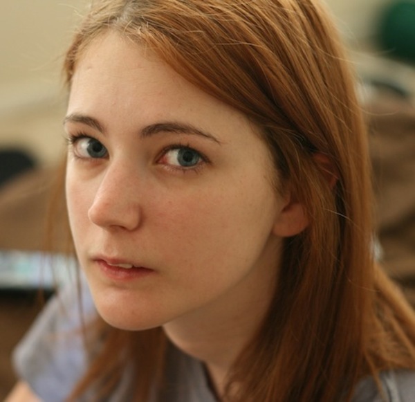 a young woman with long red hair and blue eyes