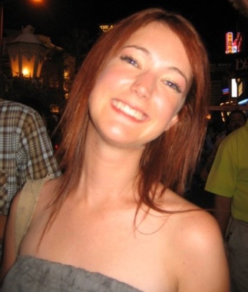 a woman with red hair and a man in the background