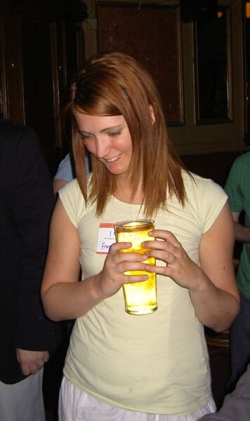 a woman in a yellow shirt holding a drink