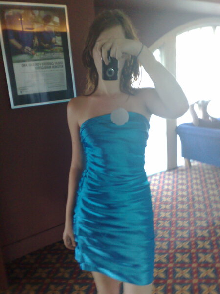 a woman in a blue dress taking a picture of herself