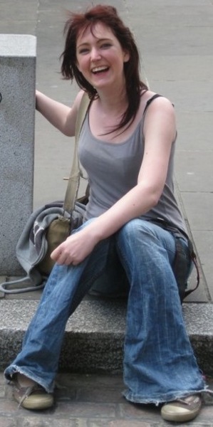 a woman sitting on a stone bench with a backpack