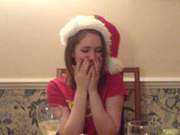 a woman in a santa hat sitting at a table