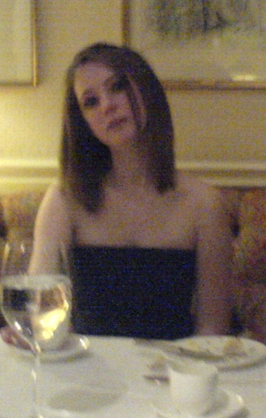 a woman sitting at a table with a glass of wine