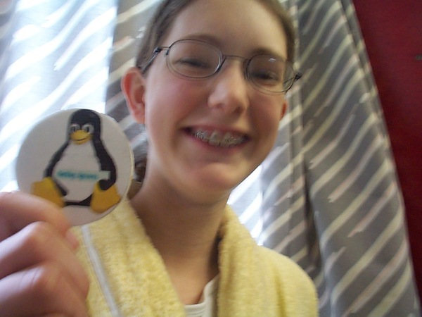 a girl in a yellow robe holding a penguin pin