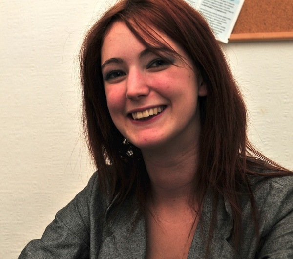 a woman sitting at a table with a cup