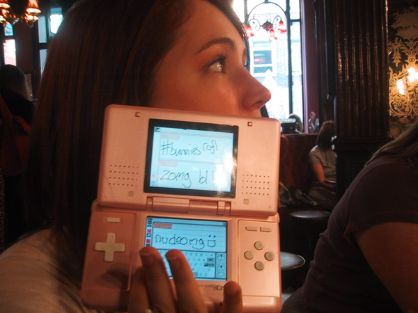 a woman holding a pink nintendo game console ted