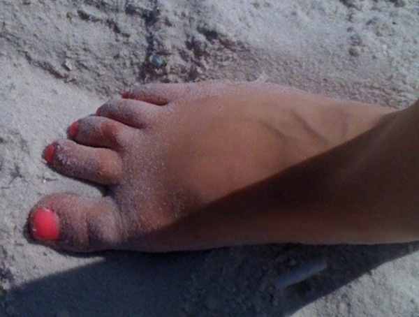 a person's feet with red nail polish