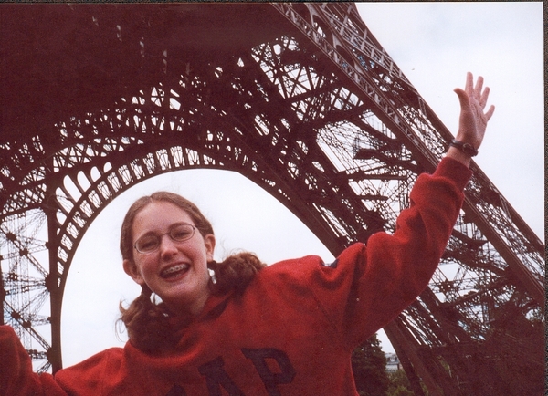 a woman in a red sweater is standing in front of the Eiffel Tower 6 a