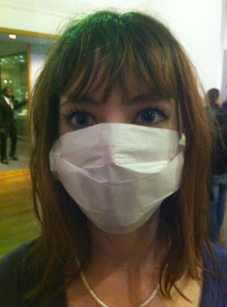 a woman wearing a mask in an airport