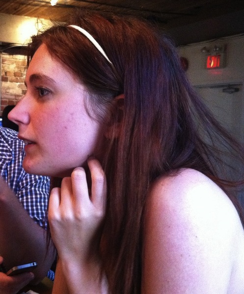 a woman sitting at a table with a cellphone