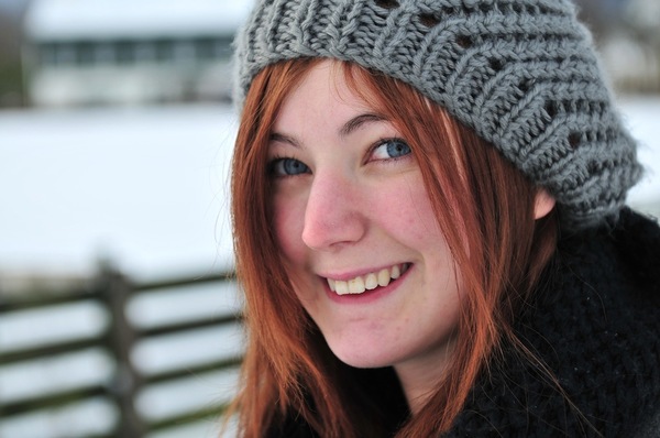 a woman wearing a knit hat with a smile