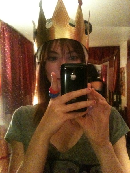 a woman taking a picture of herself wearing a crown