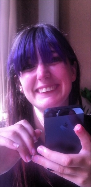 a woman with blue hair holding a cellphone