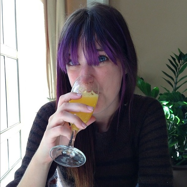 a woman drinking a glass of orange juice