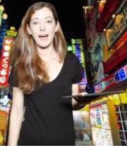 a woman standing in front of a neon lit street