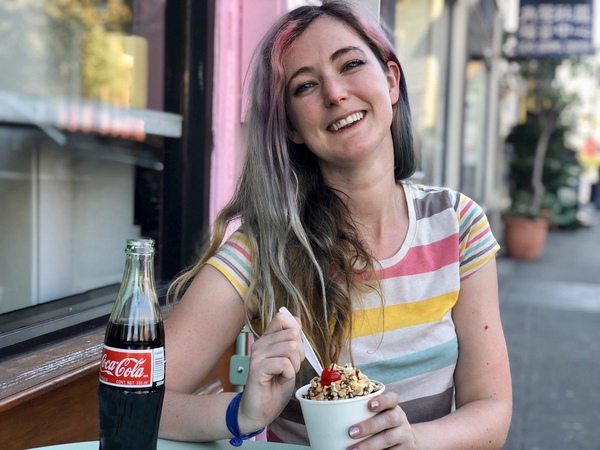 a woman sitting at a table eating a bowl of food