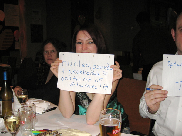 a man and woman holding up signs at a table