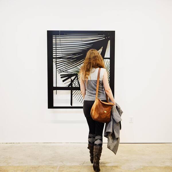 a woman is walking in front of a painting =

a
=
&
| 4
A
;