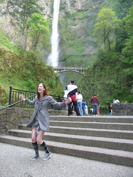 a woman is walking up some stairs near a waterfall