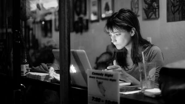 a woman sitting at a table with a laptop