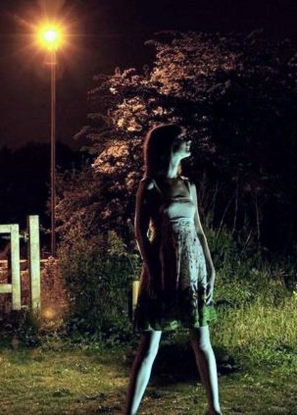 a woman walking down a street at night