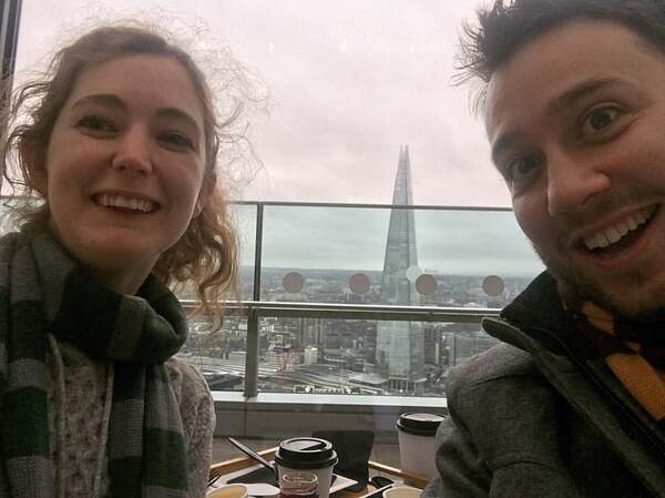 a man and woman sitting at a table with a cup of coffee