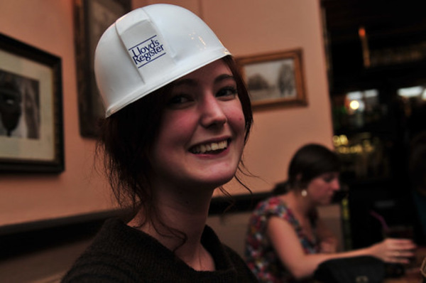 a woman wearing a hard hat and holding a cellphone