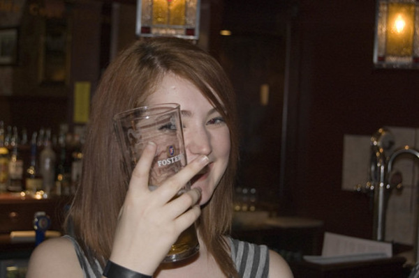 a woman drinking a glass of beer