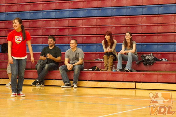 a group of people sitting on a bench in a gym