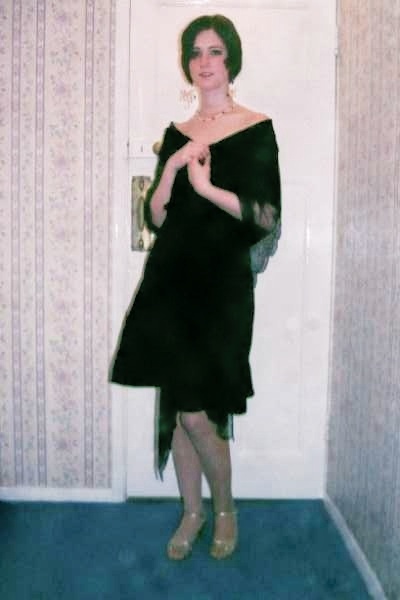 a woman in a black dress standing in a room