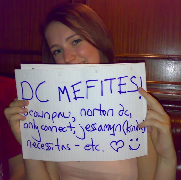 a woman holding a sign that says, DC MEFITES 4 on cone 5 es014 kat — |
Ateptas- ete COU ;