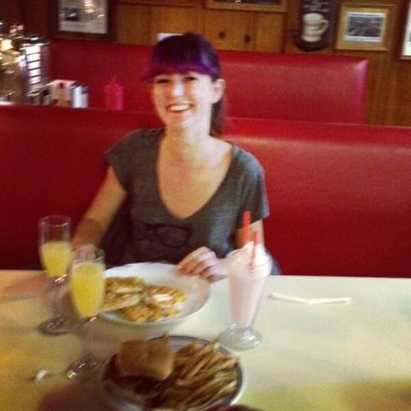 a woman sitting at a table with plates of food