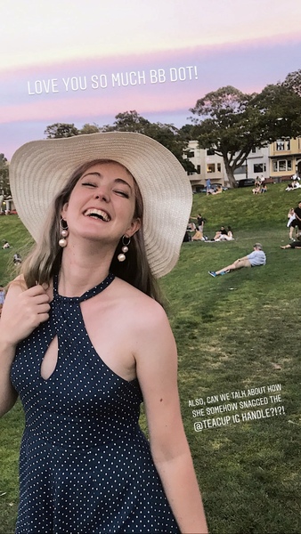 a woman in a hat and dress standing in a field