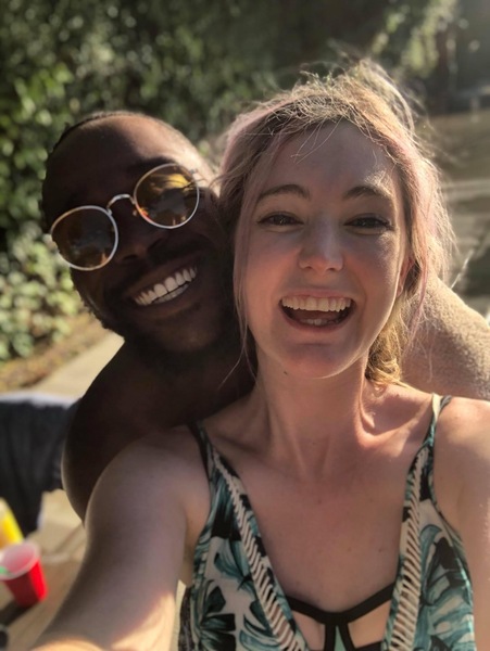 a woman in a bathing suit and sunglasses smiles at the camera while a man in a bathing suit and sunglasses smiles at the camera