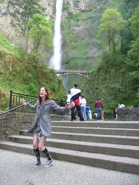 a woman is standing on some steps near a waterfall