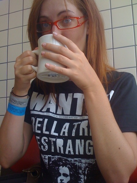 a woman with glasses drinking from a cup