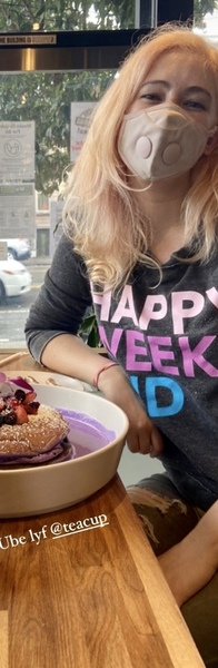 a girl sitting at a table with a plate of food