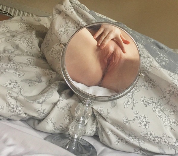 a baby is laying in a bed with a mirror