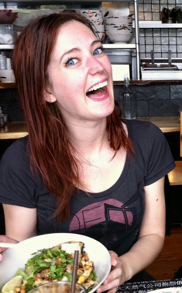 a woman sitting at a table with a plate of food