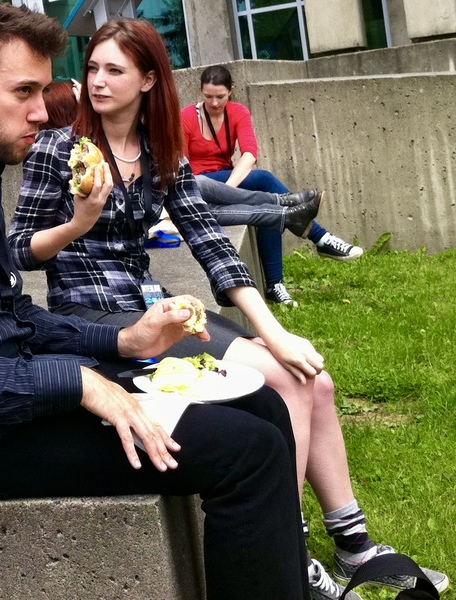 a man and woman sitting on a bench eating food