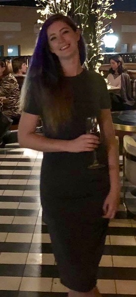 a woman in a black dress standing in a restaurant