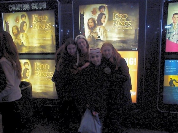 three women standing in front of a movie theater