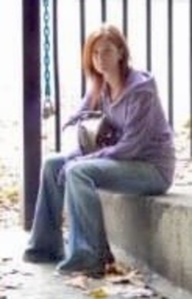 a woman sitting on a bench in the park